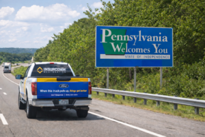 Insurcomm truck next to Pennsylvania state road sign